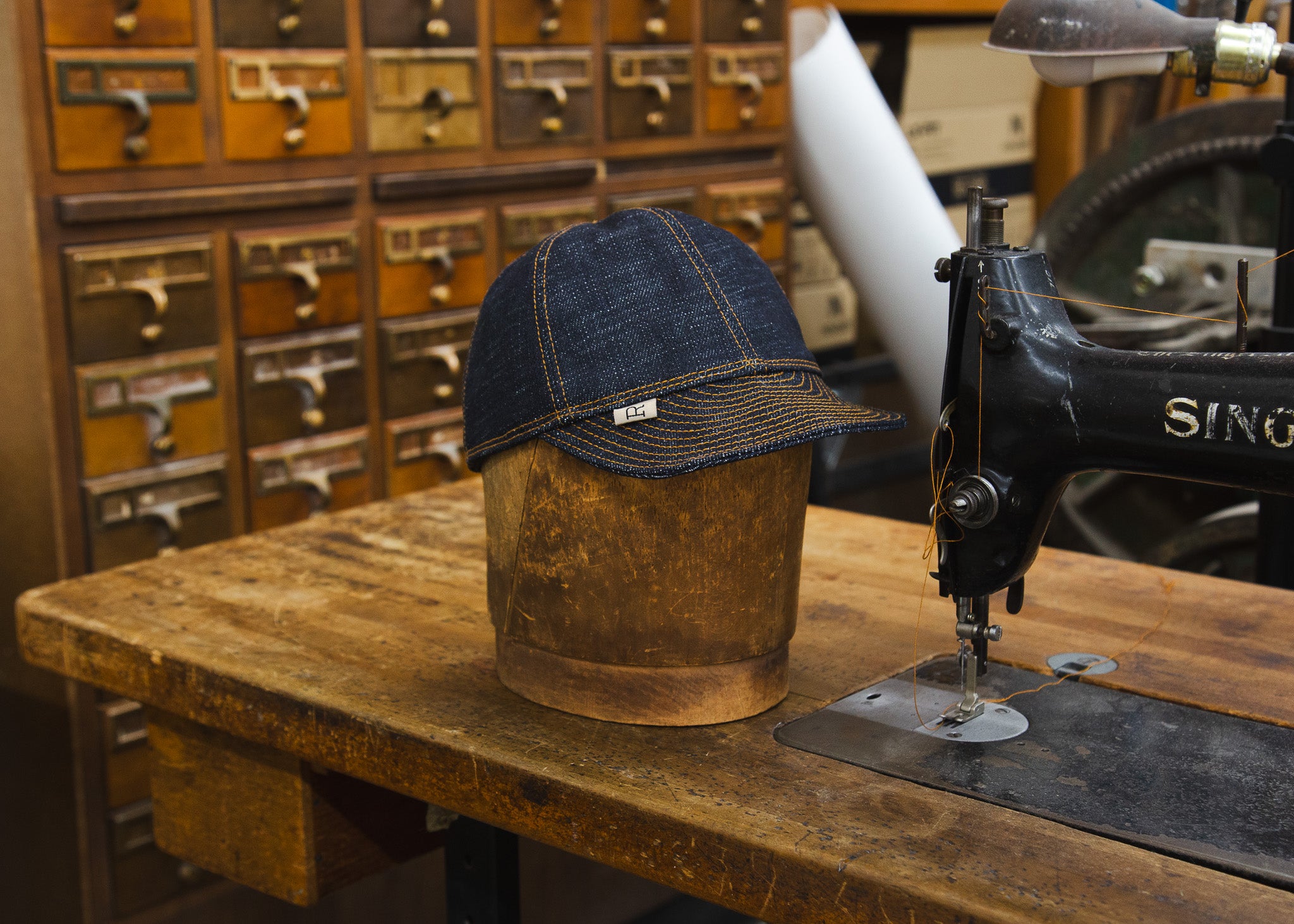 Front of 20 ounce Mechanic Hat next to sewing machine