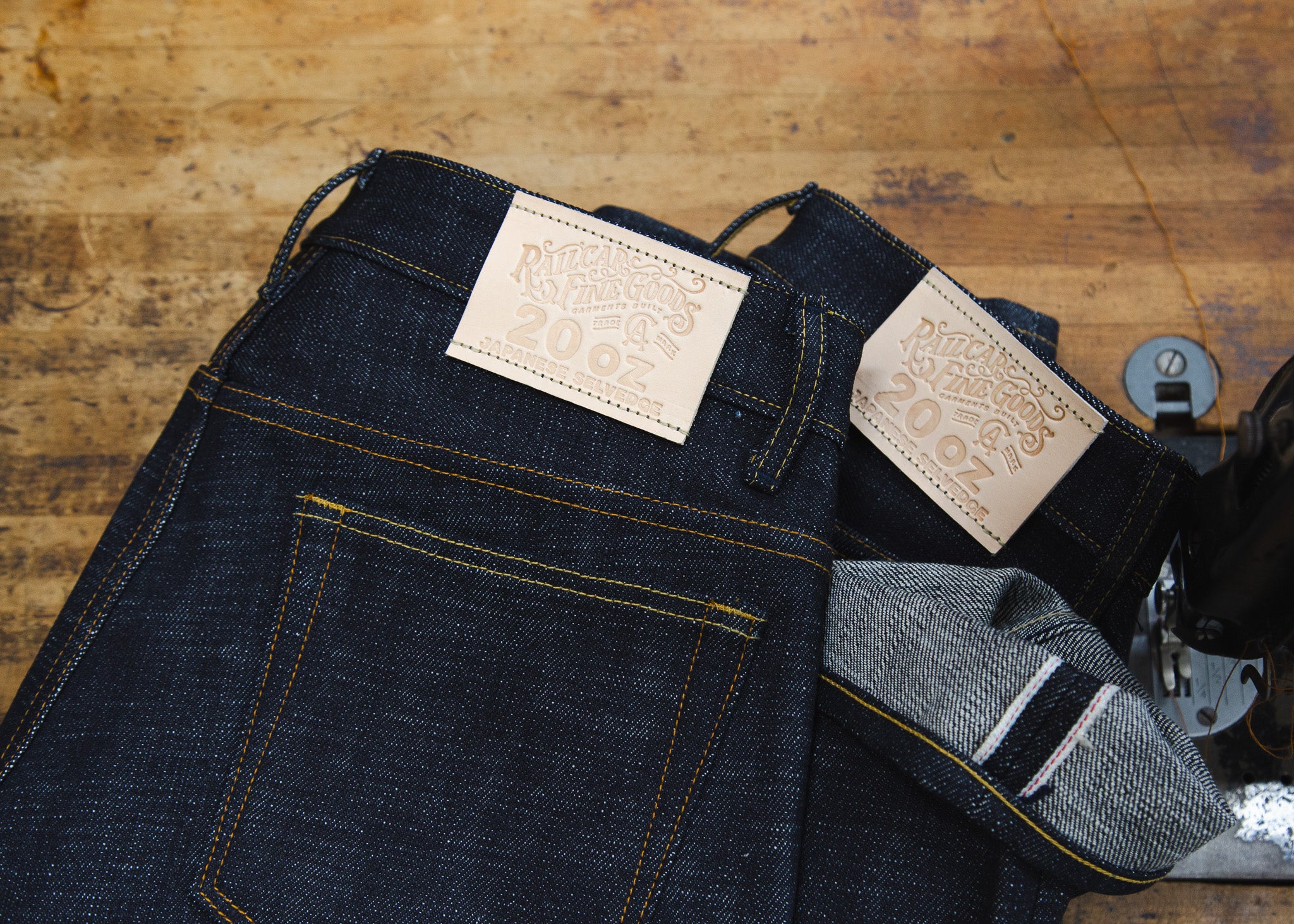 Close Up of 2 pairs of 20 ounce Jeans next to sewing machine