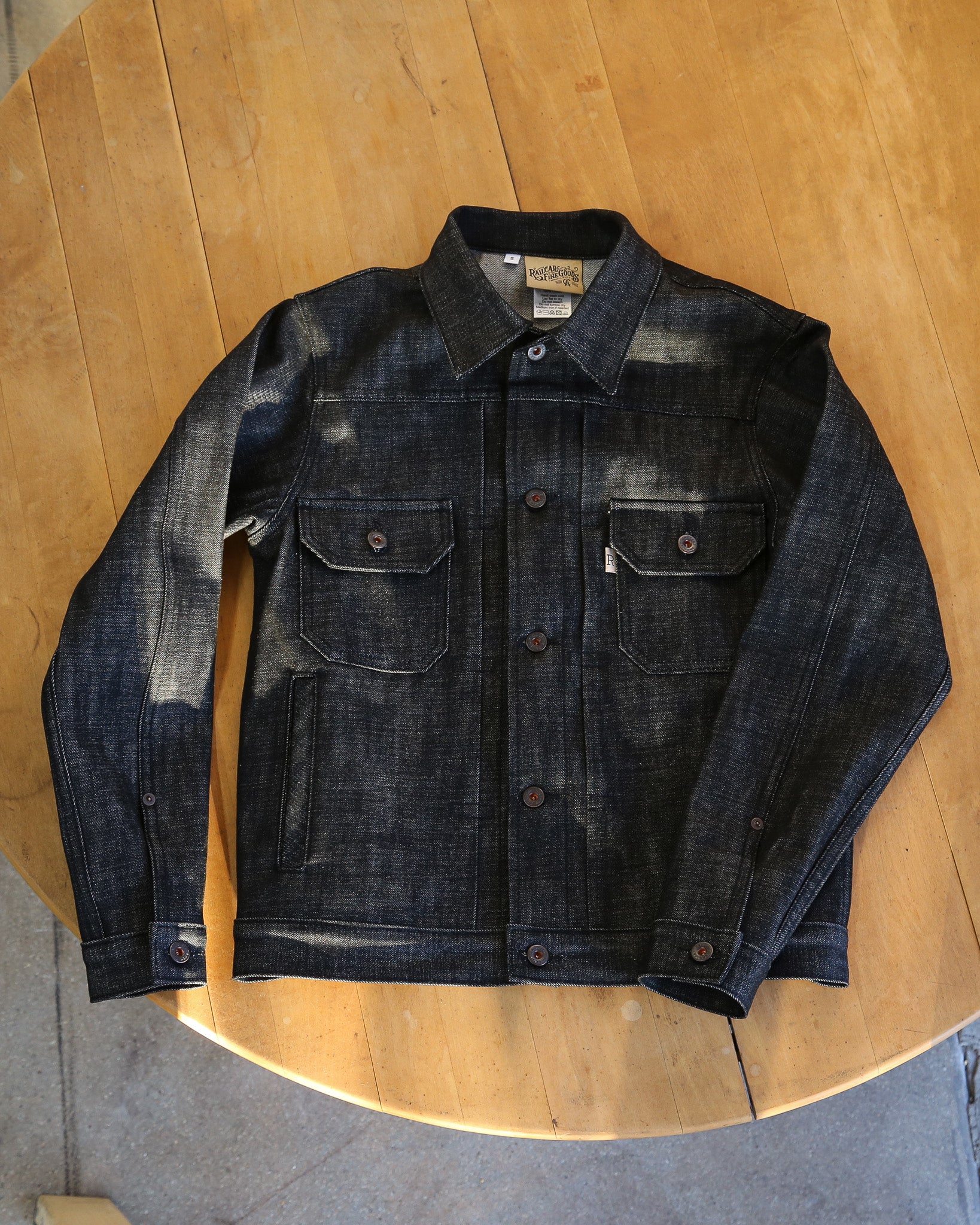 Dark denim jacket on a wooden surface
